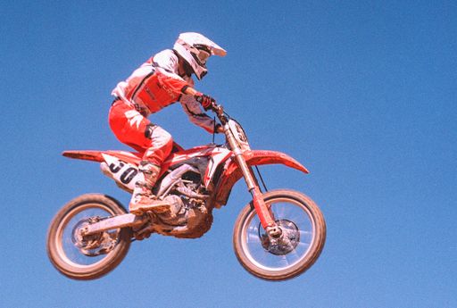 A motocross red motorbike Honda CFR in the mud track