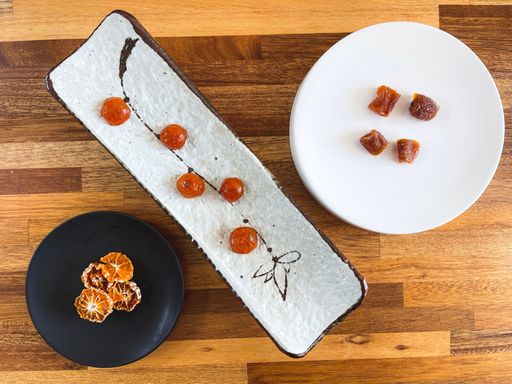 A top view of Candied fruit on decorated and colorful plates on a wooden luxury table