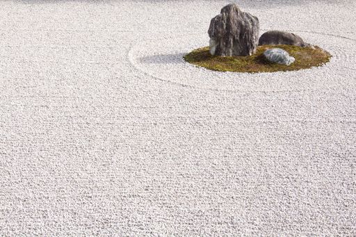A high angle shot of the beautiful rocks surrounded by white gravel captured in a Japanese garden