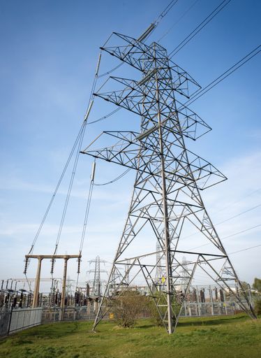 Pylon next to electricity substation connecting high voltage power lines