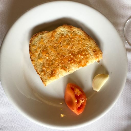 A high angle shot of a plate of bread and tomato a traditional Catalan Spanish meal on a table