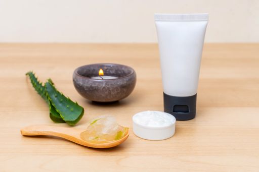 A candle and aloe vera cosmetic cream for face and body care