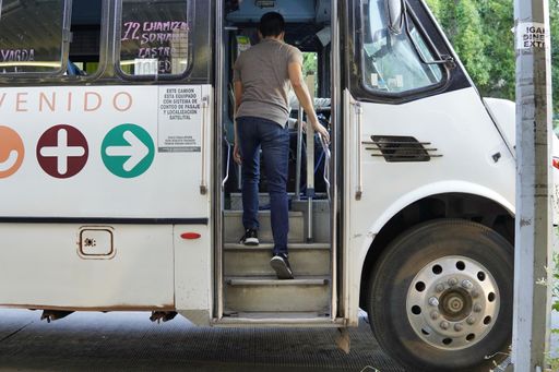 young man with mask getting bus