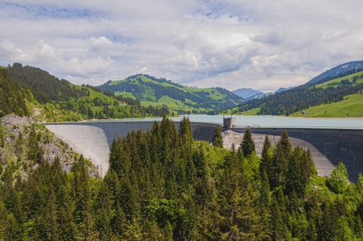 A beautiful shot of Lac de l'Hongrin under a cloudy blue sky - perfect for travel blog