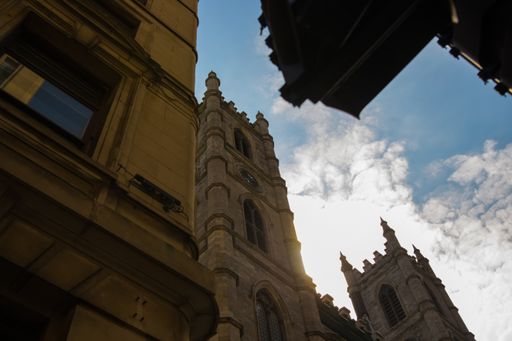 A low angle shot of the Notre-Dame Basilica of Montreal on the cloudy sky background