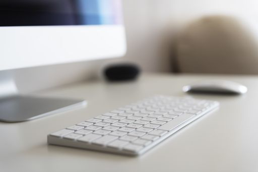 A work desk with a computer on a blurred background