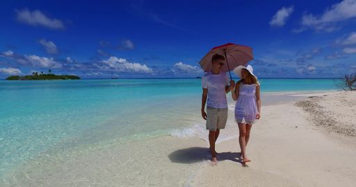 A couple on the beach in Rasdhoo Atoll, Rasdhoo Island, The Maldives celebrating honeymoon