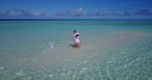A couple on the beach in Rasdhoo Atoll, Rasdhoo Island, The Maldives celebrating honeymoon