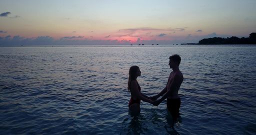 A couple on the beach in Rasdhoo Atoll, Rasdhoo Island, The Maldives at sunset