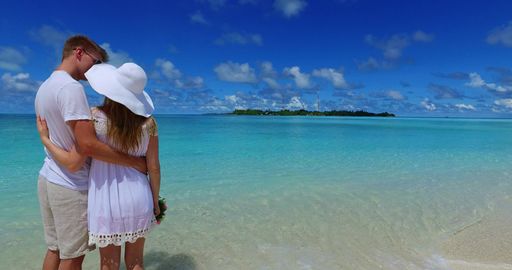 A couple on the beach in Rasdhoo Atoll, Rasdhoo Island, The Maldives celebrating their honeymoon