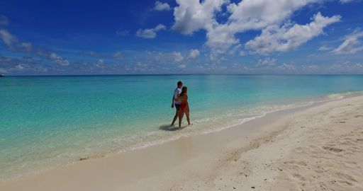 A young couple walking around and having fun on the shore of Rasdhoo Island in the Maldives