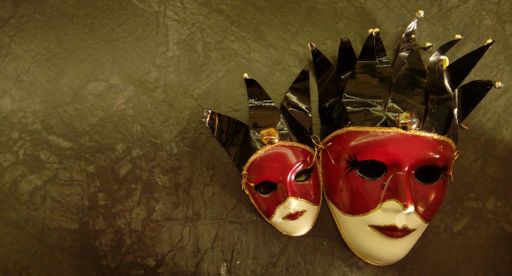 A closeup shot of two red and white theater masks with copy space for text