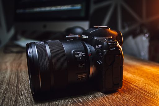 A closeup shot of a Canon R mirrorless camera on a wooden table