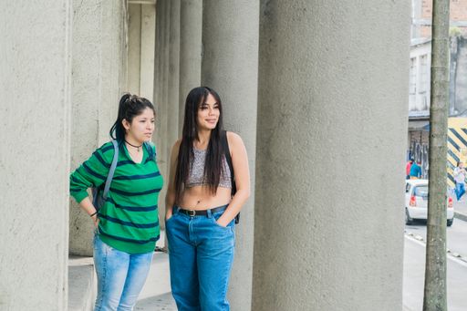 A two beautiful women  walking down the street while observing and criticizing others, concept of gossip