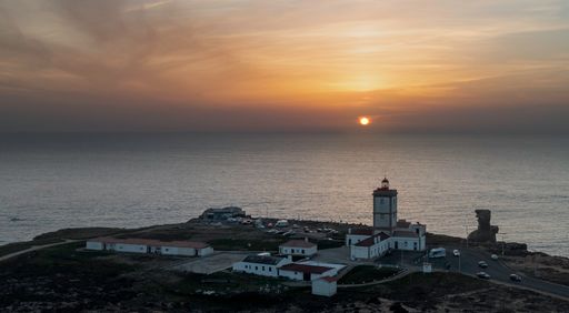 A beautiful picture at sunset, Cape da Roca and the red lighthouse on the edge of a cliff in Portugal.