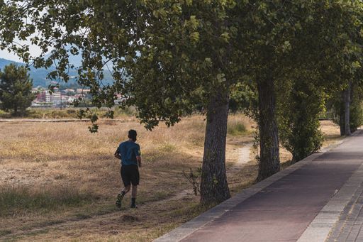 A male running through the field near the road
