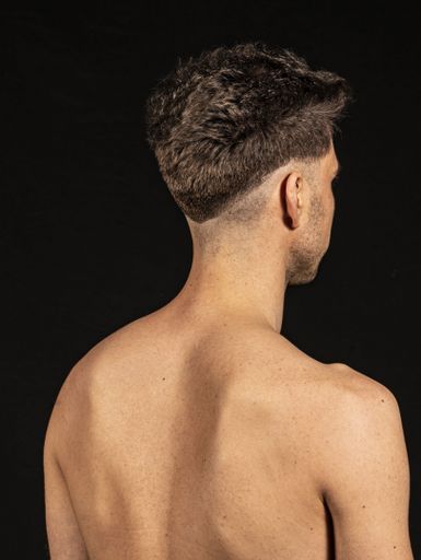 A shallow focus shot of a young male isolated on black background