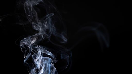 A white smoke creating abstract shapes on a black background