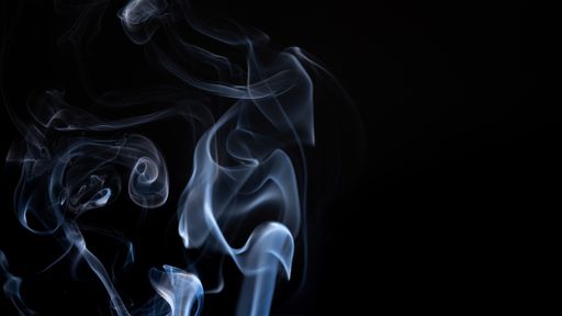 A white smoke creating abstract shapes on a black background