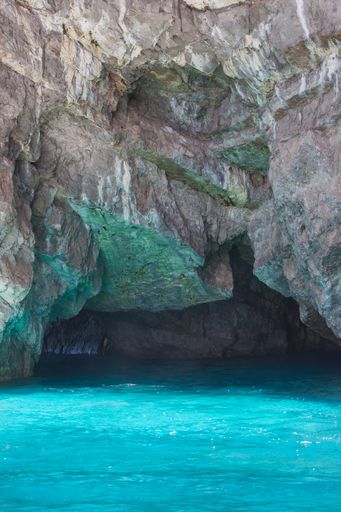 A vertical shot of a sea cave with amazing turquoise water in Amalfi coast in Italy