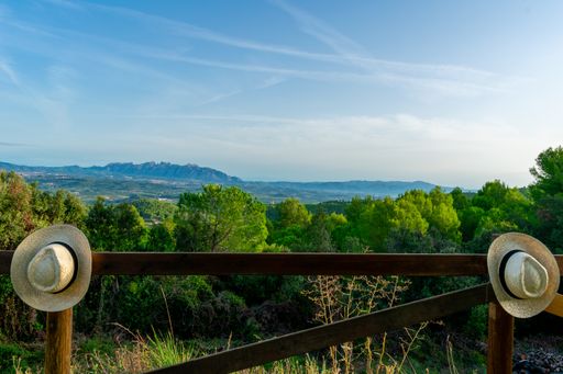 A wooden fence with thatch hats on a beautiful mountain landscape background