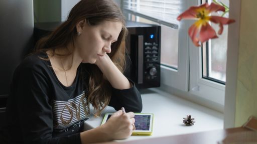 A closeup of the woman working on the tablet.