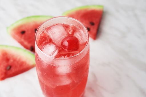 A high angle shot of a red drink near watermelon slices