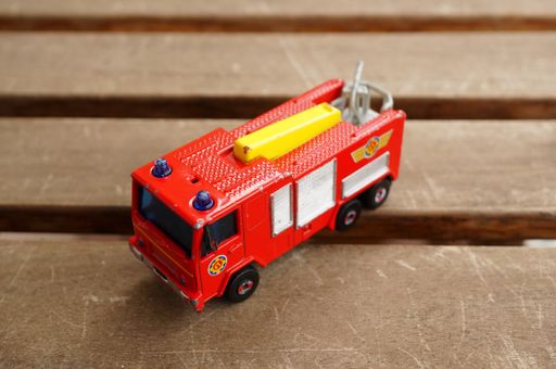 Fireman Sam toy Jupiter fire truck on a wooden surface. Horizontal high angle view.