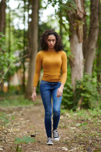 A vertical selective focus shot of a young female walking in the park