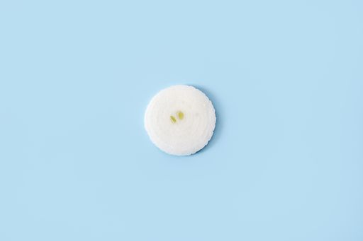 An overhead shot of a slice of onion on a blue background