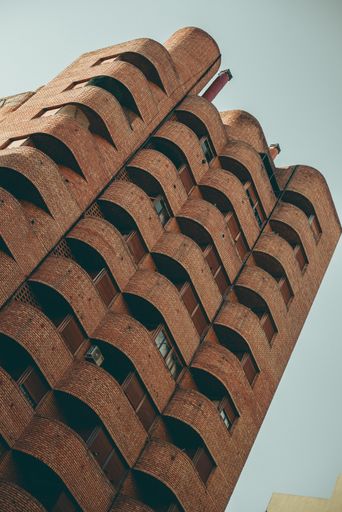 A low angle shot of modern architectural design of a building with blue sky in the background