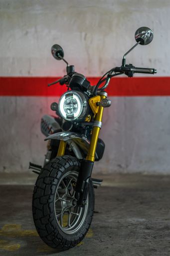 A horizontal shot of a yellow and black motorcycle in an underground parking