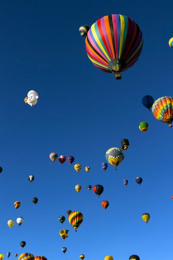 A vertical shot of hot air balloons in the bright sky in Albuquerque, USA