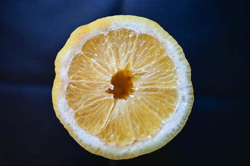 A closeup shot of a juicy lemon isolated on a blue background