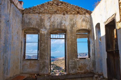 A low angle shot of old temple ruins with high mountains and the beautiful blue sky in the background in Greece