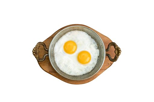 A top view of fried eggs in the pan isolated on a white background