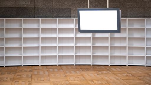 A room with an empty white bookcase and a screen