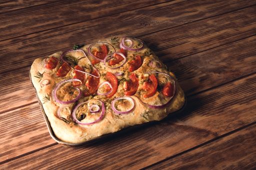 A high angle shot of a square-shaped pizza on a wooden table