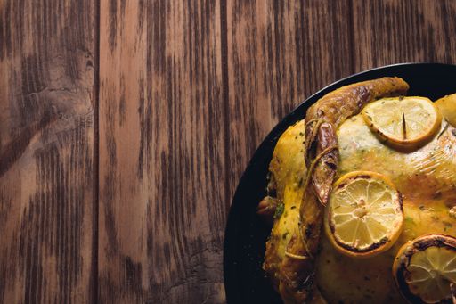 An overhead shot of a delicious dish cooked with chicken on a wooden table