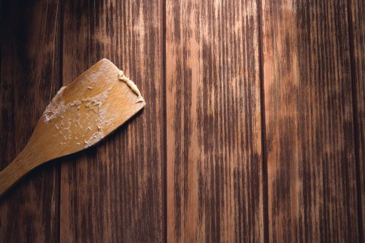 A closeup shot of a wooden spatula on a wooden table