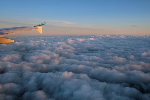 The Beautiful view over the clouds from a plane window at the sunrise