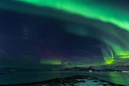 A beautiful shot of the Northern lights over the sea near Tromso, Norway