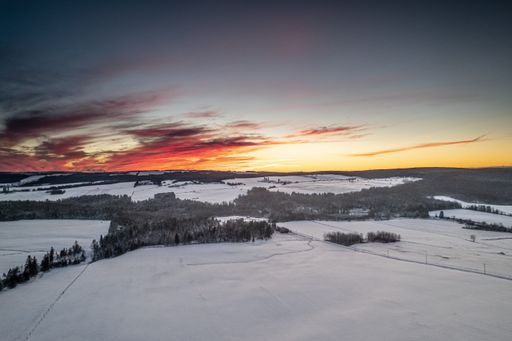 A beautiful shot of a landscape covered in snow during the sunset