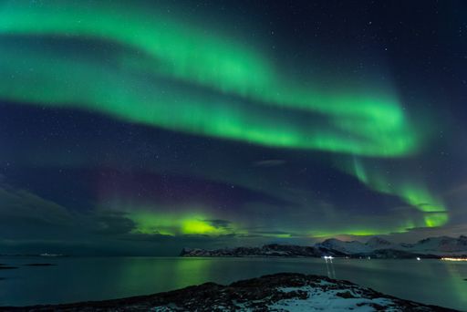 A beautiful shot of the Northern lights over the sea near Tromso, Norway