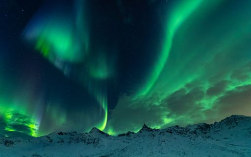 A beautiful shot of the Northern lights over the sea near Tromso, Norway