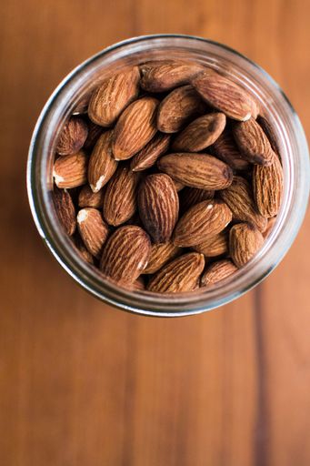 A vertical selective overhead shot of almonds in a jar