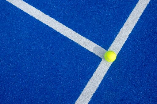 Bright blue tennis, paddle ball or pickleball court close up of service line outdoors.