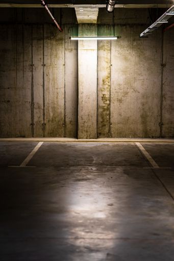 The vertical shot of an Empty parking lot with an overhead dim light