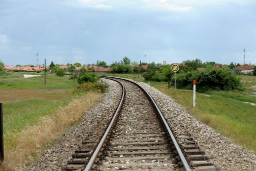 A rural railroad through a green field