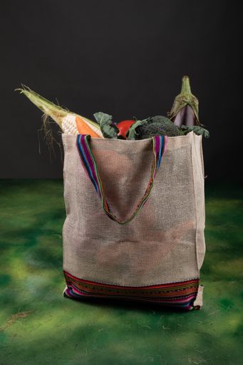 A vertical shot of fresh vegetables in an eco bag on the table - environmental concept